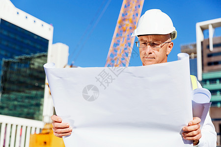 安全工程师建筑工地的工程师建设者工程师建筑工人施工场景穿着带蓝图的安全背心背景