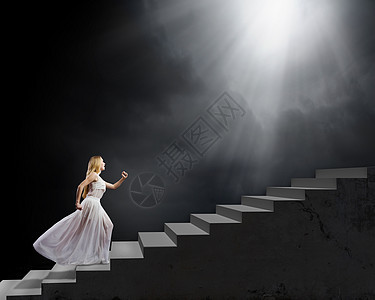 穿白色衣服的女人穿着白色长裙的轻女人走上楼梯图片