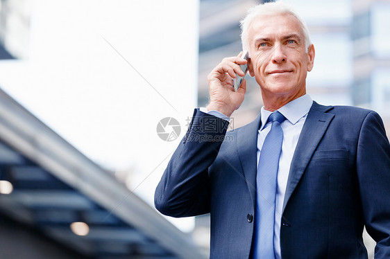 户外自信商人的肖像自信商人的肖像与他的手机户外图片