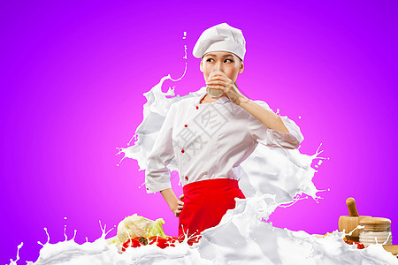 亚洲女厨师抗牛奶飞溅亚洲女厨师牛奶溅红色围裙与颜色背景饮用牛奶图片