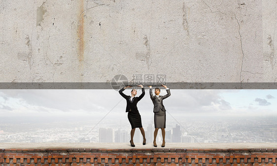 女人搬墙两个女商人举水泥墙文字的位置图片