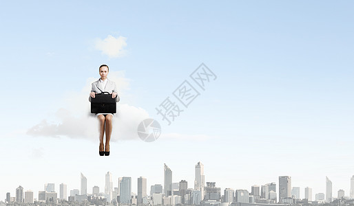 云上的女人轻漂亮的女商人坐城市上空的云端上图片
