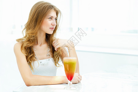 年轻漂亮的女人坐咖啡馆里喝着杯饮料图片