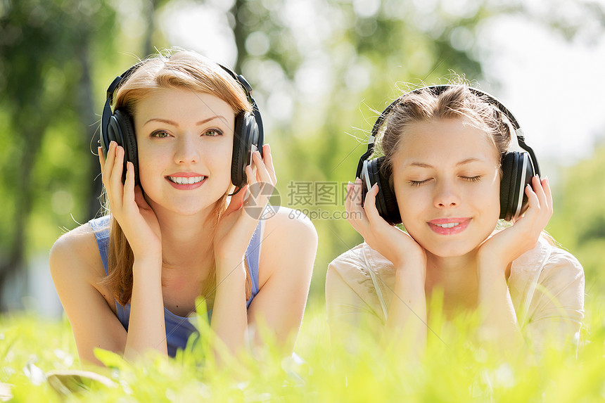夏天的公园野餐夏天公园里轻迷人的女孩戴着耳机图片