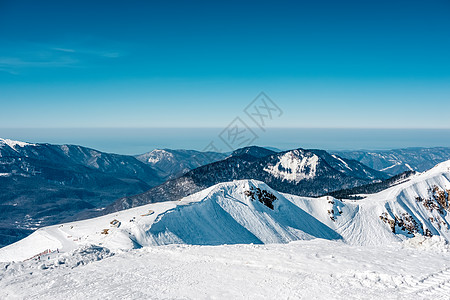 冬天的山景阳光明媚的日子里,高加索山脊上覆盖着雪克拉斯纳亚多拉那,索契,俄罗斯图片