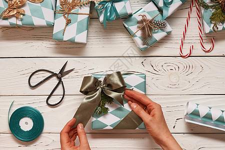 女人包装诞礼物创造地包装装饰诞礼物盒子上的木制背景顶部的视图图片