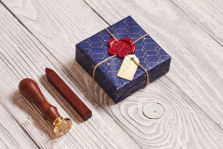 创造地包装装饰诞礼物盒子蜡密封邮票上的白色木制背景图片