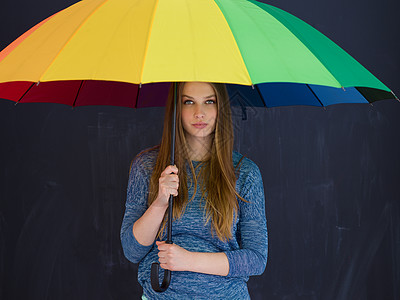 位轻英俊的女人的肖像,她带着把五颜六色的雨伞,孤立灰色的背景上图片