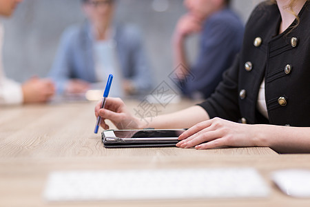 轻的女商人用笔特写镜头的手图片