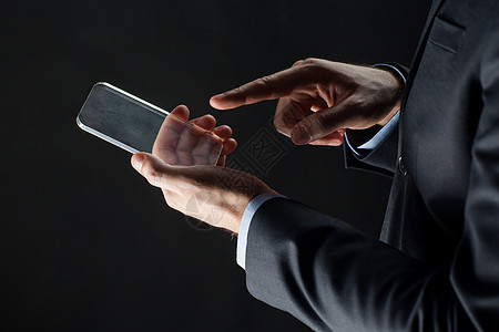 商业,人未来的技术商人的手与透明智能手机比黑色图片