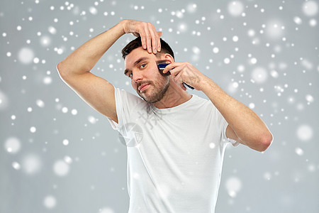 美丽,修饰,冬天,诞节人们的微笑的轻人剃须胡须与修剪机电动剃须刀雪地上的灰色背景图片