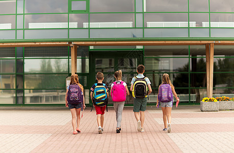 小学教育,友谊,童人的群快乐的小学生带着背包后走户外图片