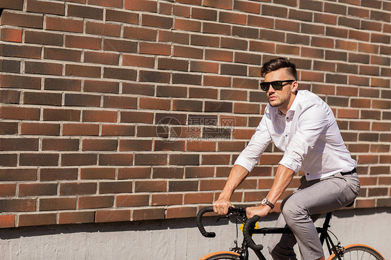 生活方式,交通人们的戴太阳镜的轻人骑自行车城市街道上的砖墙图片