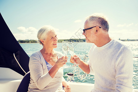 游艇香槟航海,龄,旅行,假期人们的快乐的老夫妇海上漂浮的帆船游艇甲板上碰碰香槟杯背景