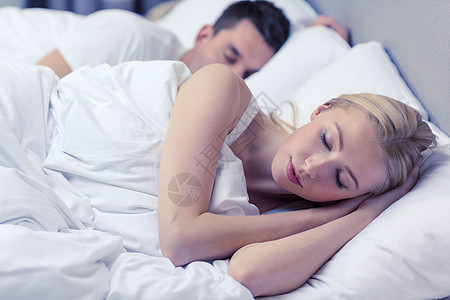 酒店,旅行,人际关系幸福幸福的夫妇睡床上背景图片