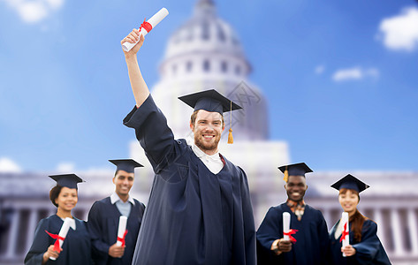 教育毕业人的群快乐的国际学生穿着灰浆板学士礼服与文凭超过美国白宫背景图片