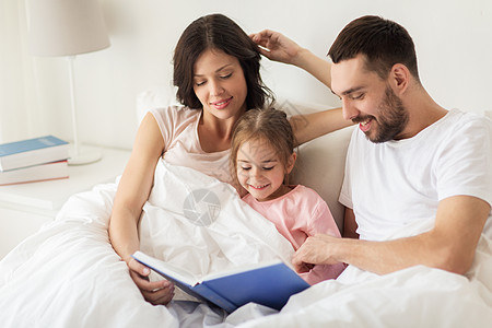 人,家庭早晨的快乐的孩子与父母家里床上看书图片