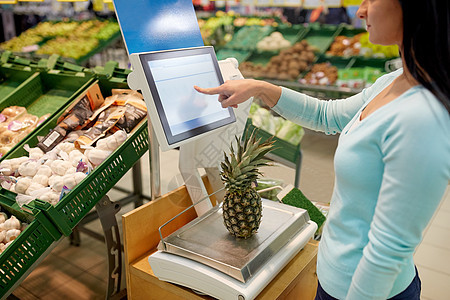 购物销售消费主义人们的观念杂货店里称菠萝的女人图片