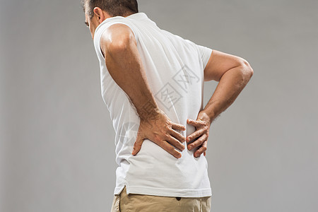 人,医疗保健问题密切的人遭受痛苦的背部灰色背景图片