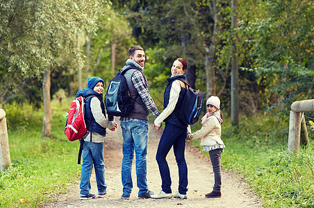 冒险,旅行,旅游,徒步旅行人们的快乐的家庭步行与背包树林回首图片