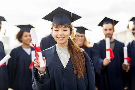 教育,毕业人的群快乐的国际学生迫击炮板学士学位礼服与文凭图片