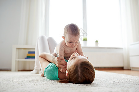 家庭,孩子父母的快乐微笑的轻母亲家里小婴儿玩耍图片