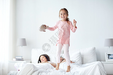 人,家庭早晨的快乐的孩子与玩具父母床上家图片