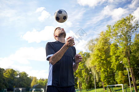 体育,足球人足球运动员球场上用头球技术玩杂耍球图片