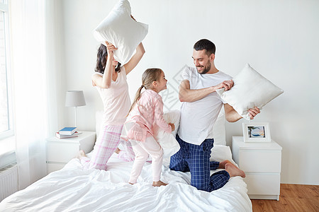 人,家庭早晨的快乐的孩子与父母床上枕头打架家图片