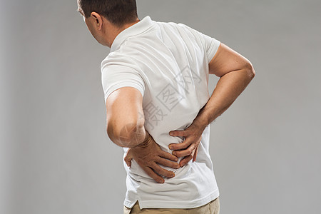 人,医疗保健问题密切的人遭受痛苦的背部灰色背景特写患背痛的人图片
