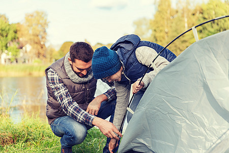 野营,旅游,远足,家庭人的快乐的父子户外搭帐篷快乐的父子户外搭帐篷图片
