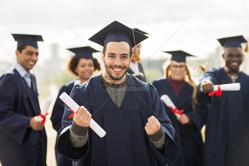 教育手势人的群快乐的国际学生穿着灰浆板学士服,毕业证书庆祝成功毕业带着文凭庆祝毕业的快乐学生图片