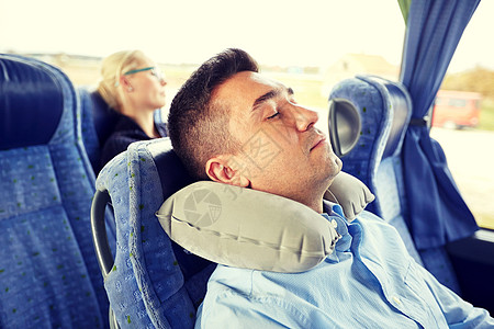 睡着的男人交通,旅游,休息,舒适人的男人睡旅行巴士与颈充气枕头男人睡旅行巴士上带着颈枕背景