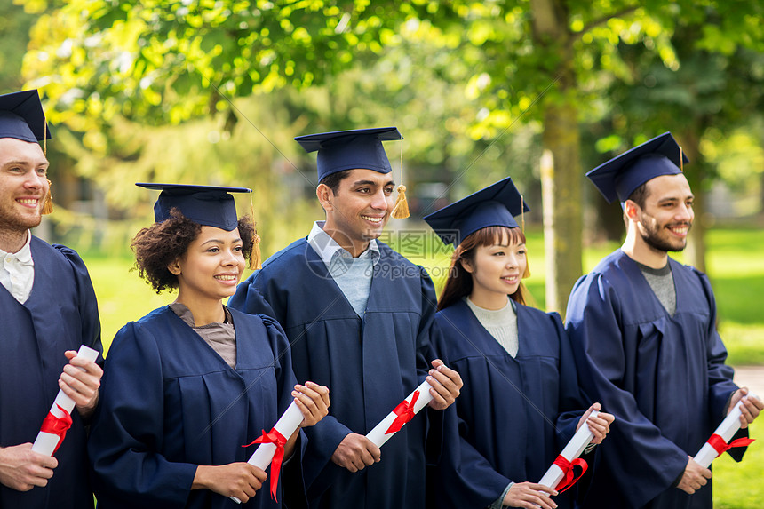 教育,毕业人的群快乐的国际学生迫击炮板学士学位礼服与文凭文凭的迫击炮板上快乐的学生图片