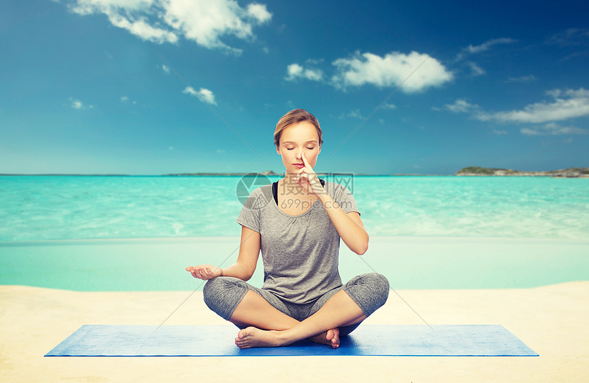 健身,运动,人健康的生活方式妇女海上天空背景的垫子上莲花姿势的瑜伽冥想女人海滩上冥想莲花瑜伽姿势图片