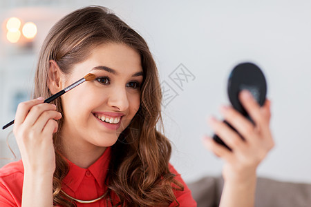美丽,化妆,化妆品人的快乐的微笑轻妇女应用眼影刷镜子家里眼影刷镜子的女人化妆背景图片