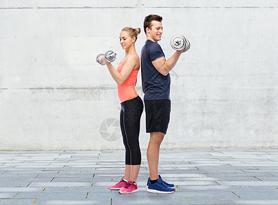 运动,健身人的快乐的运动男女哑铃弯曲肌肉混凝土墙壁背景哑铃的男男女女图片