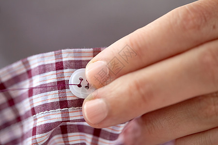 人,针线,缝纫裁剪裁缝妇女与针缝按钮衬衫女人纽扣上缝针衬衫背景图片