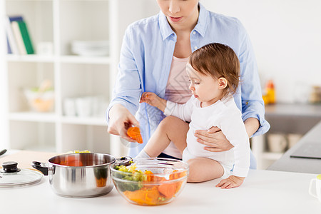 家庭,食物,健康饮食,烹饪人的快乐的母亲小女婴与蔬菜锅家里厨房快乐的母亲婴儿家煮蔬菜图片