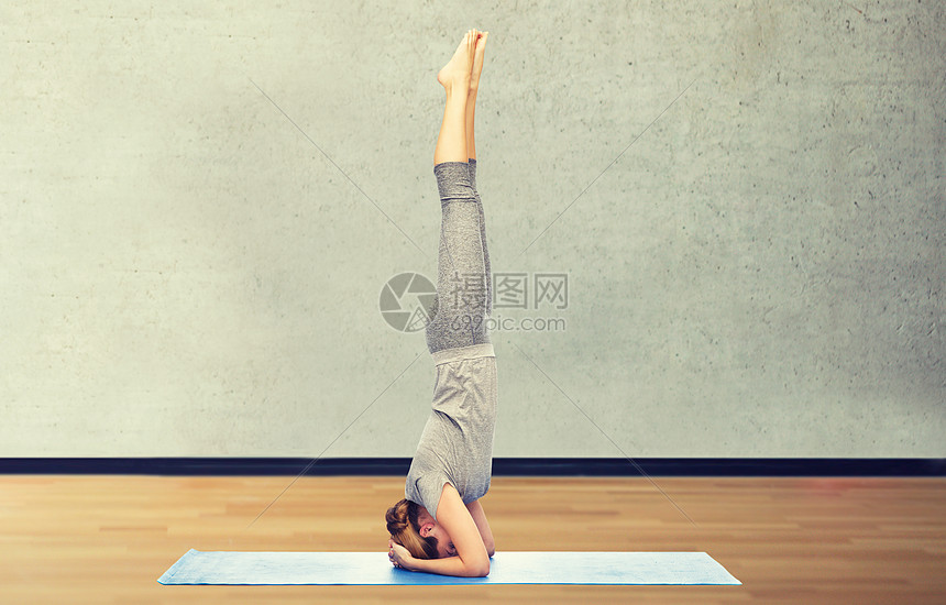 健身,运动,人健康的生活方式妇女瑜伽头倒立姿势垫子上的房间健身房背景女人垫子上倒立姿势瑜伽图片