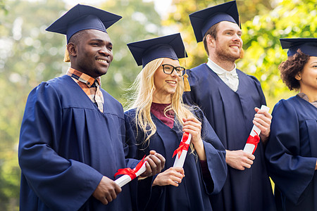 教育,毕业人的群快乐的国际学生迫击炮板学士学位礼服与文凭文凭的迫击炮板上快乐的学生图片