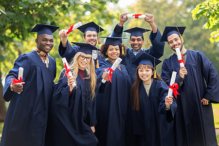 教育,毕业人的群快乐的国际学生迫击炮板学士学位礼服与文凭文凭的迫击炮板上快乐的学生背景图片