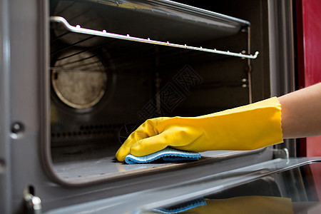 人,家务家务手橡胶手套与抹布清洁烤箱家里厨房家庭厨房用抹布清洁烤箱图片