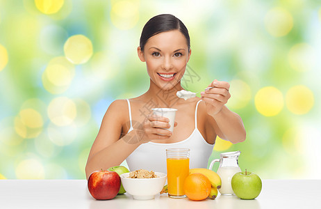 饮食,健康食品人们的快乐的女人与水果谷类食品,早餐绿色的夏季灯光背景下吃酸奶快乐的女人吃水果,谷类食品吃酸奶图片