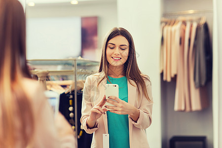 购物,时尚,风格,技术人的快乐的女人与智能手机采取镜子自拍服装店女人商店用智能手机自拍图片