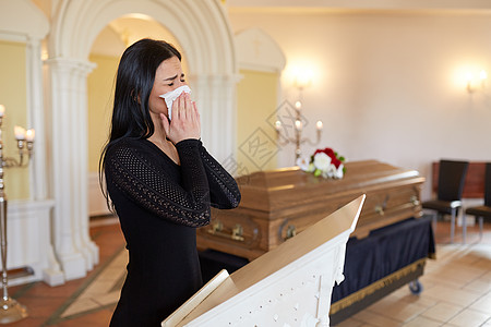 小鼻子埋葬,人,悲伤哀悼的教堂的葬礼上,悲伤的女人棺材附近用餐巾哭泣教堂的葬礼上,棺材附近哭泣的女人背景