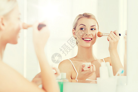 美容,化妆,化妆品,早上人的微笑的轻女人化妆刷粉底家里的浴室镜子浴室里化妆刷粉末的女人图片