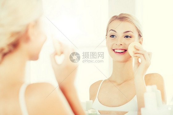 美容,护肤人的微笑的轻女人洗她的脸与部清洁海绵浴室轻女子浴室用海绵洗脸图片