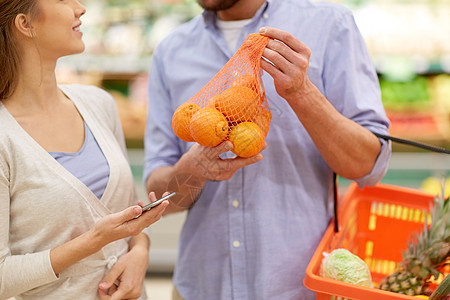 购物,食品,销售,消费主义人的幸福的夫妇与智能手机购买橘子杂货店超市夫妇用智能手机杂货店买橘子夫妇图片