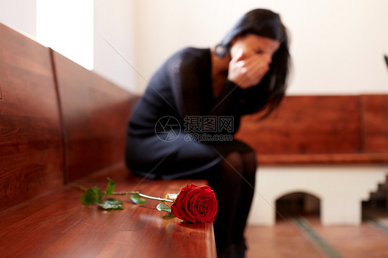 人们,悲伤哀悼的哭泣的女人与红玫瑰坐长凳上的葬礼教堂教堂的葬礼上哭着带着红玫瑰的女人图片